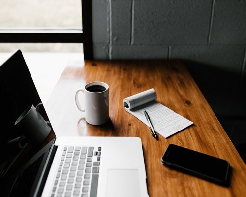 phone notebook and coffee on a work desk